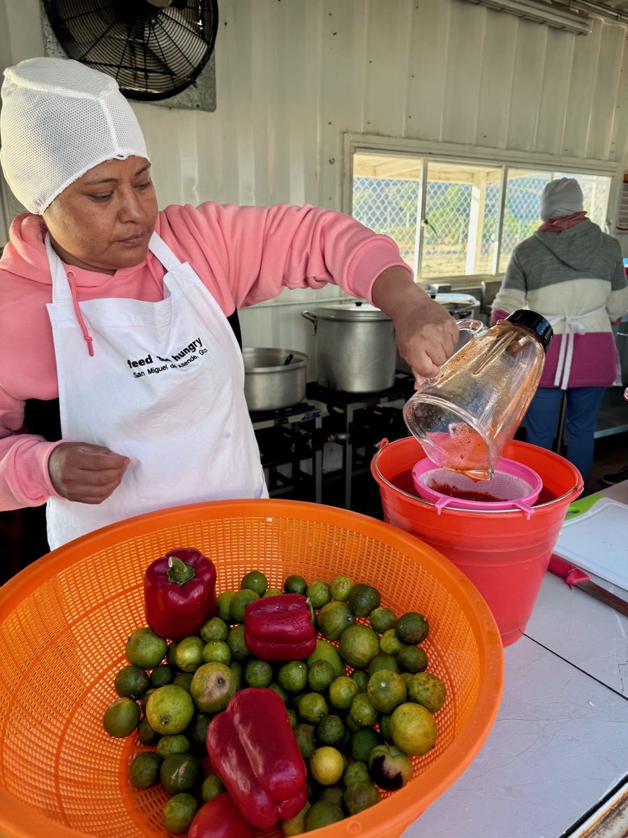 Cook preparing fresh vegetables in a Feed the Hungry school kitchen